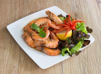 Shrimp boiled with honey and salt in white dish on dark table thai food