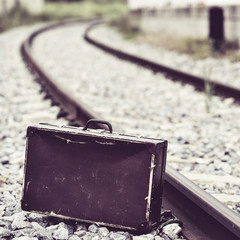 suitcase next to the railroad tracks