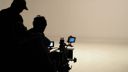 Silhouette of production film crew or working people are making movie or commercial shooting with...