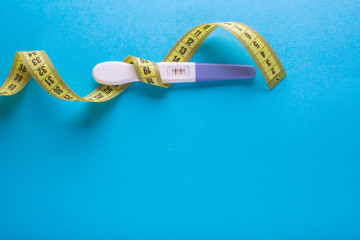 Diet for pregnant women. Pregnancy test and measuring tape.