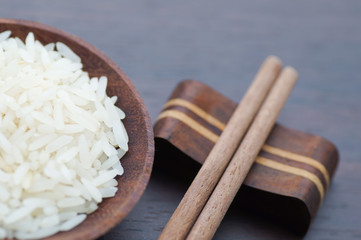 Thai rice with chopsticks on wood background