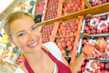 Shop assistant holding peaches