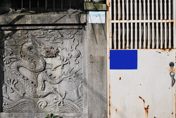 An abandoned old house with a dragon sculpture on wall.