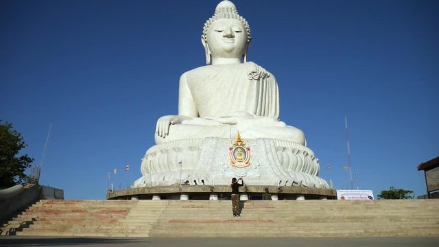 Young Tourist Girl Taking Photo of White Big Buddha Statue at Phuket, Thailand. HD.