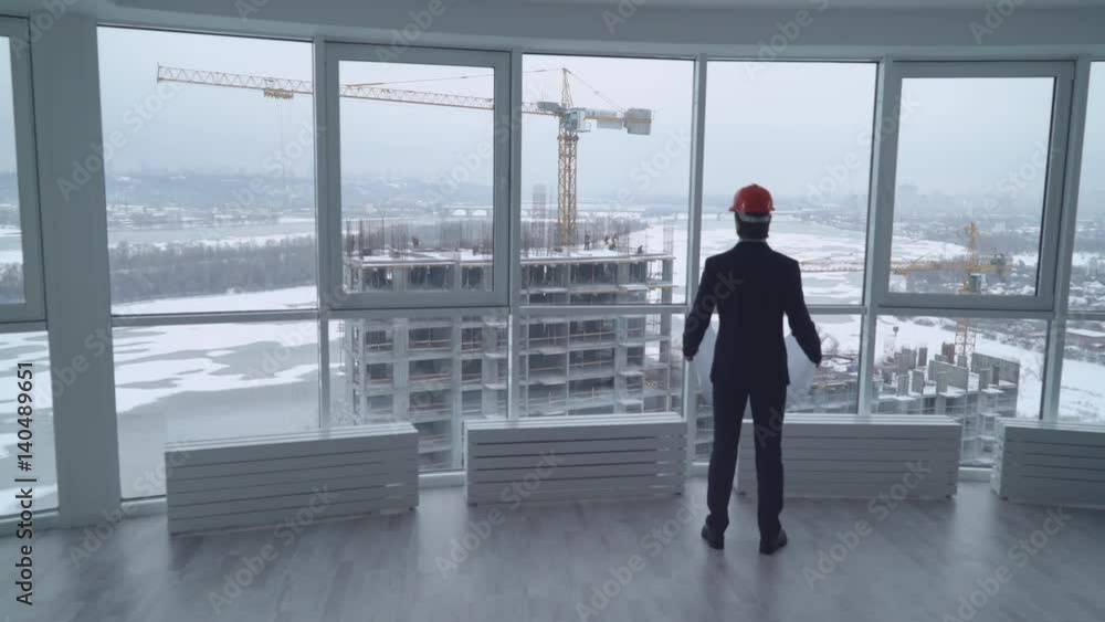 Aufkleber engineer architect looking on the plan. rear back view man in the office looking through the windows