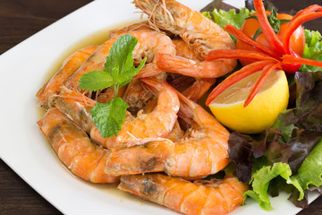 Shrimp boiled with honey and salt  in white dish on dark table