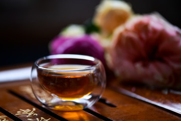 Fresh tea in glass cup over wooden table background