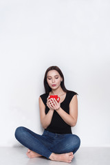  Woman sitting on floor with cup of tea or coffee