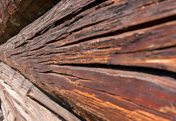 Wall of old cracked logs. Perspective side view. - obrazy, fototapety, plakaty