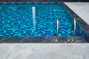 Handrail beside blue swimming pool