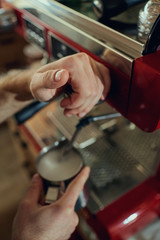 The hands of  barista bartenders make an espresso of coffee on  machine in cafe bar. Closeup.