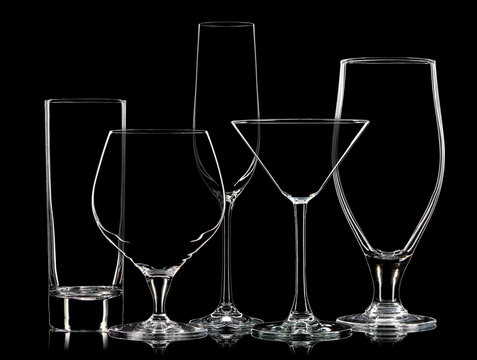 Silhouette of different glasses on black background.