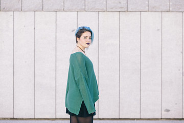 Teen androgynous woman with blue dyed hair isolated on the street