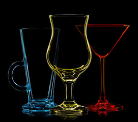 Silhouette of multicolor different glasses on black background