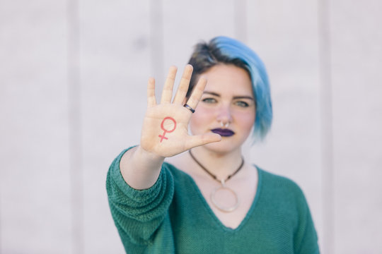 symbol of feminism written on a woman hand isolated on the street