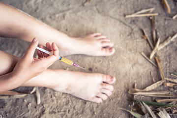 Drug addict young woman with syringe in action