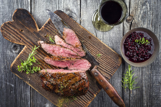 Barbecue Vanison Steak as top-view on old Cutting Board