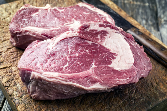 Dry Aged Rib-Eye Steak as close-up on old Cutting Board