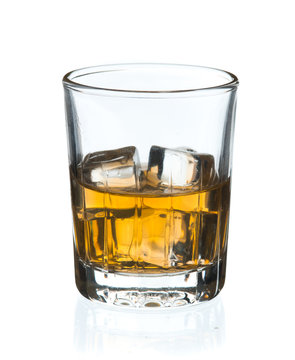 Glass of whisky with ice on a white