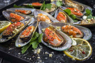 Baked Green Shell Mussels as close-up on old rustic sheet