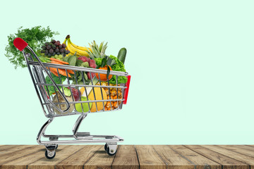 Einkaufswagen gefüllt mit frischem Obst und gemüse. 