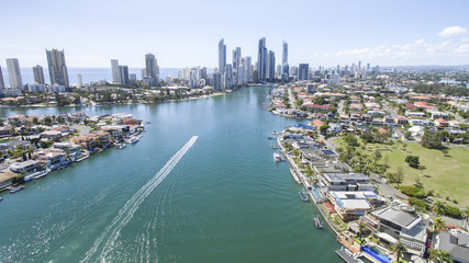 Fototapeta na wymiar Aerial view of Gold Coast waterways between Macintosh and Cronin Islands with a speed boat heading towards Surfers Paradise