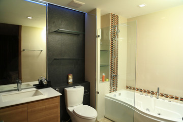 Warm tone of luxury interiors design of the bathroom with jacuzzi in condominium, as background or print card.