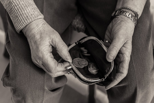 Elderly lady's hands checking money in her purse.