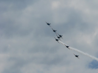 Squadron of fighter jets in clouds on sunny day