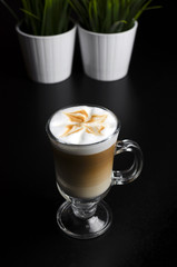 Coffee latte in a glass with green grass on the background