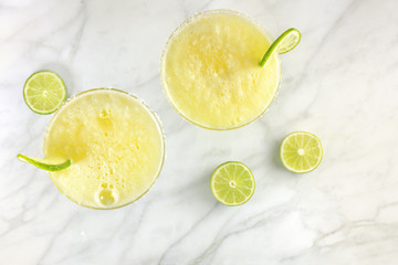Lemon Margarita cocktails with limes and copy space