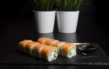 Sushi with trout and avocado with chopsticks
