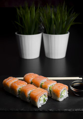 Sushi with trout and avocado with chopsticks