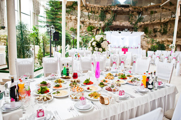 Wedding guest table with flowers and food at wedding hall.