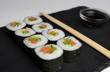 Sushi of norimaki with trout and salad on slate plate