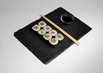 Sushi of norimaki with trout and salad on slate plate