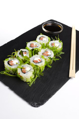 Green sushi on slate plate with bamboo sticks