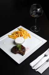 Beef steak with French fries on a white plate