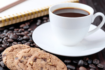 Coffee cup and coffee beans on wooden background