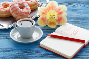 Cup of coffee and litter notebook with word 