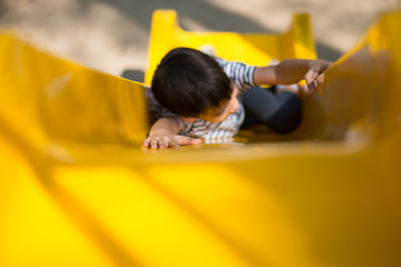 Little boy playing slider at playground