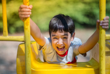 Little boy playing slider at playground