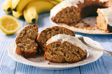 Banana cake with poppy seeds on wooden table.