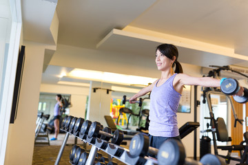 Fitness girl lifting dumbbell in gym