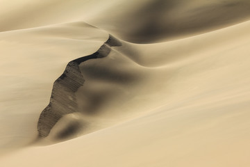 Shifting sand dune contrasts. Desert or beach sand textured background.