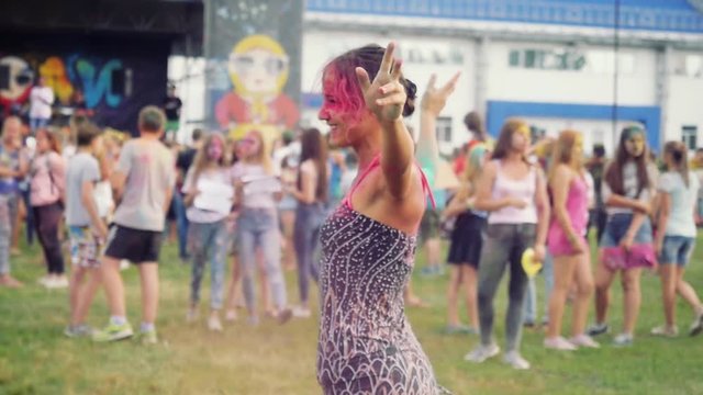 Colour of Holi Kick to the Face of young pretty woman in Slow Motion.dancing and having fun. 1920x1080. Group of young friends in the Park with the colors of Holi