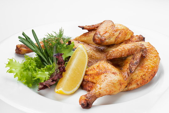  Chicken grilled and served with green salad on a white background