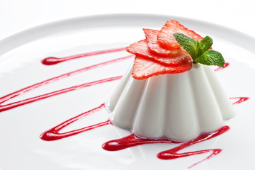 Dessert panna cotta aux fraises sur une assiette blanche. Fermer