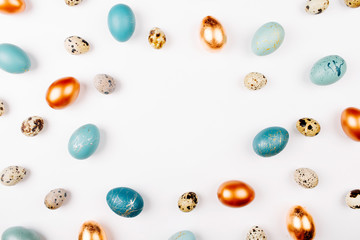 Stylish Frame background with quail, gold and blue easter eggs with copy space for text. isolated on white background. Flat lay, top view. Easter concept.