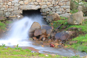 Water stream coming out of a traditional old water mill in full activity © juanorihuela